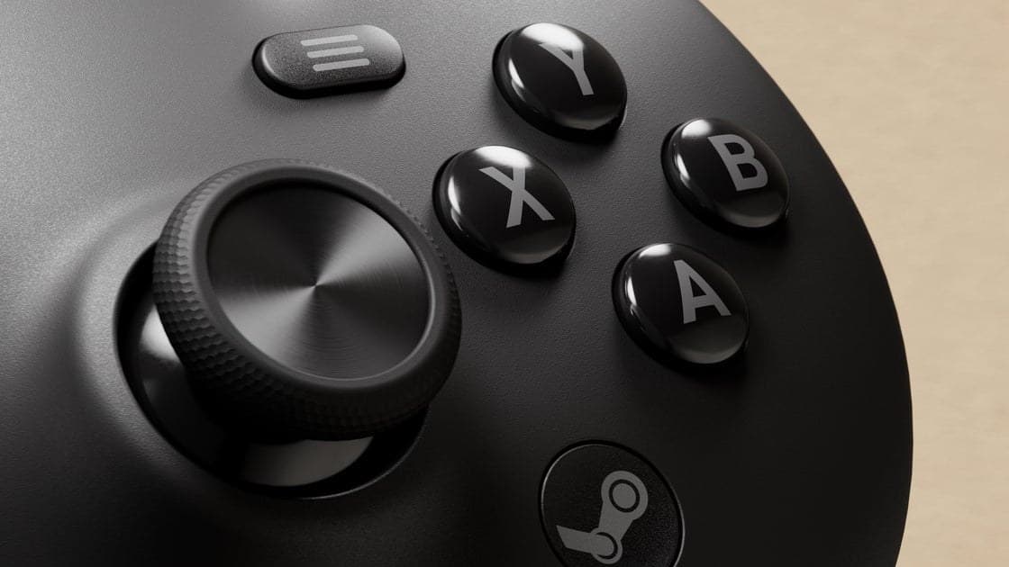 Steam Machine console and Steam Controller sitting on a desk beside a monitor