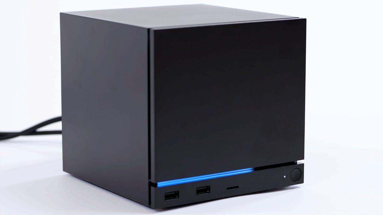 Valve Steam Machine gaming PC hardware sitting on a desk with controller